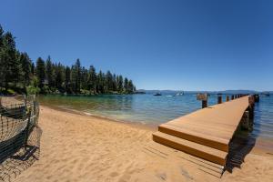 a dock on a beach with trees and water at Foothill Folly home in Zephyr Cove