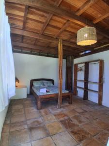 a bedroom with a bed and a wooden ceiling at Bicho Grilo Hostel in Atins