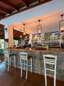 a bar with white chairs in a restaurant at KATIA BEACH Holiday Cottage in Kassiopi +8 photos