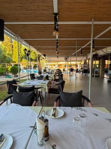 a restaurant with tables and chairs with white table cloth at KATIA BEACH Holiday Cottage in Kassiopi