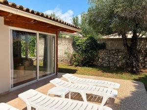 a group of white chairs sitting on a patio at KATIA BEACH Holiday Cottage in Kassiopi