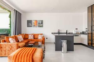a living room with an orange couch and a kitchen at The blue Mirage II in Tangier