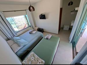 a small bedroom with a bed and a window at Chalet Alta Vista Acuruí in Itabirito