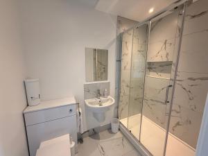 a white bathroom with a shower and a sink at Fishergate Residences in Preston
