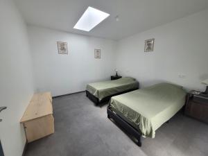 a room with two beds and a table in it at Les écuries in Secondigny