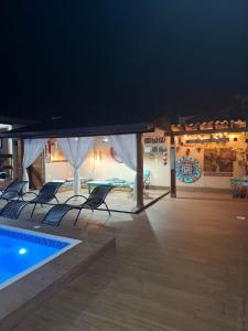 a patio with chairs and a swimming pool at night at Recanto dos Guimarães in Palhoça