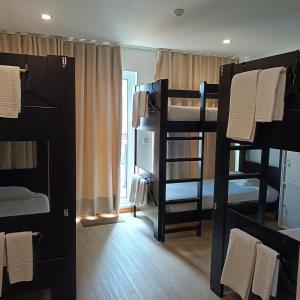 a room with four bunk beds and a window at Santa Alegria Hostel in Ponta Delgada