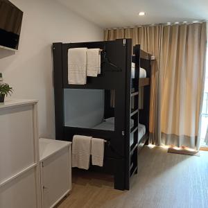 a black bunk bed in a room with towels at Santa Alegria Hostel in Ponta Delgada
