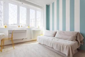 1 dormitorio con cama y paredes de rayas azules y blancas en Riva Reno Apartment, en Bolonia