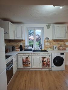 a kitchen with white cabinets and a sink and a window at Romantic house by the River in Pfaffenhoffen