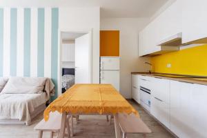 cocina con mesa y sofá en una habitación en Riva Reno Apartment, en Bolonia