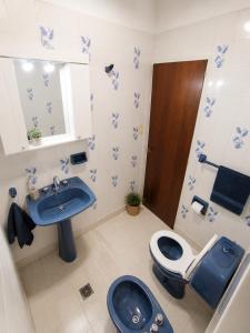 a bathroom with a blue toilet and a sink at La Casa de Miel in Villa Ballester