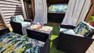 a patio with two chairs and a table with drinks at Les Trois Palmiers - Jardin & Spa privatifs in Les Bréviaires