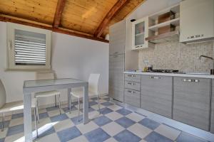 a kitchen with a table and chairs in a room at Mansarda Canarina in Marina di Pescoluse