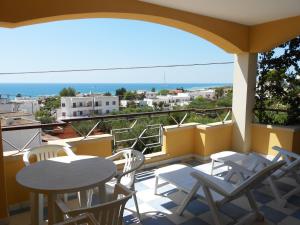 a balcony with tables and chairs and a view of the ocean at Mansarda Canarina in Marina di Pescoluse