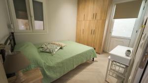 a bedroom with a green bed and a window at Meltemi Apartment in Chios