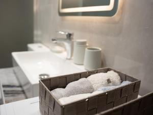 a basket of towels and a sink in a bathroom at Meltemi Apartment in Chios +34 photos
