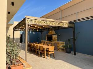 a patio with a table and chairs and a fireplace at The Mountain View in Ash Shāghūr