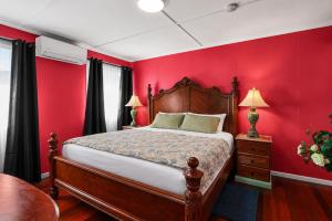 a bedroom with red walls and a large bed at Kitchener Street 2, Golden Beach in Golden Beach