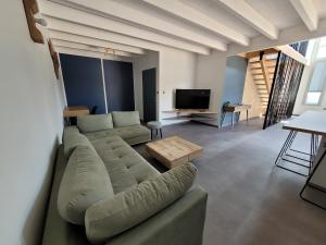 a living room with a couch and a tv at Les écuries in Secondigny