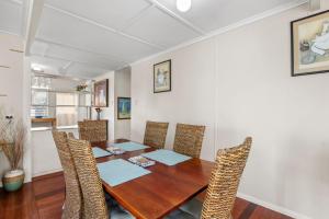 a dining room with a wooden table and chairs at Kitchener Street 2, Golden Beach in Golden Beach