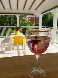 a glass of wine sitting on a table on a porch at Kaz an Fanmi in Les Abymes