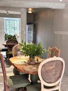 a table with chairs and a vase of flowers on it at Casa Mirabel Laurel in Fene