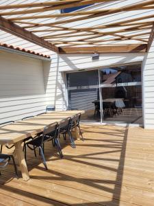 a wooden table and chairs on a wooden deck at Les écuries in Secondigny