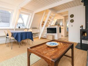 a living room with a table and a stove at 4 star holiday home in Farsø in Farsø