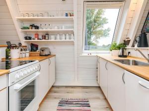 a kitchen with white cabinets and a sink and a window at 4 star holiday home in Farsø in Farsø +19 photos