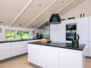 a kitchen with white cabinets and a black counter top at 5 star holiday home in Kolding in Kolding +25 photos