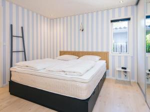 a bed in a room with a striped wall at 5 star holiday home in Kolding in Kolding
