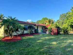 a house with a palm tree in the yard at Sunshine Acre 2B 2B King Master Suite, BIG Yard in Davie
