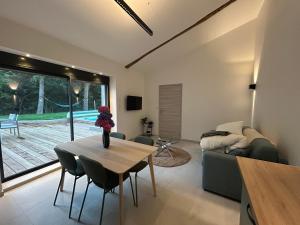 a living room with a table and a couch at Gîte Alice Piscine privée in Hauterives