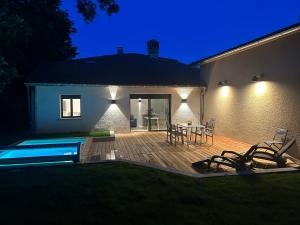 a patio with a table and chairs next to a house at Gîte Alice Piscine privée in Hauterives +34 photos