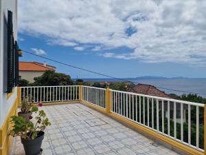 a balcony of a house with a white fence at Sol e Mar by the airport in Santa Cruz