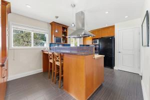 a kitchen with a large island with a counter top at Bright Coquitlam Home & Spacious Backyard in Coquitlam