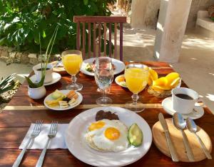 a wooden table with plates of breakfast food and drinks at Hotel Casa Maya Calakmul in Chicanna