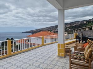 a balcony with benches and a view of the ocean at Sol e Mar by the airport in Santa Cruz