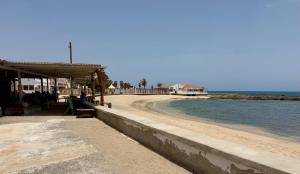 a beach with a pavilion next to the water at tud dret in Santa Maria