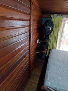 a room with a wood paneled wall and a bed at pousada nosso cantinho in Paranaguá