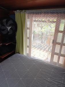 a bedroom with a window with a view of a yard at pousada nosso cantinho in Paranaguá