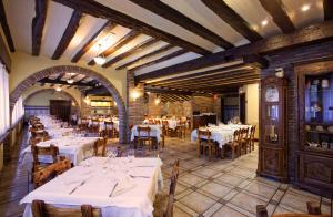 un restaurant avec des tables et des chaises blanches dans une salle dans l'établissement Hotel La Venta de Goyo, à Viniegra de Abajo