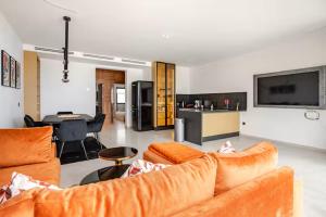a living room with orange couches and a kitchen at The Blue Mirage in Tangier