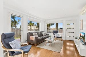 a living room with a couch and two chairs at Mariners in the Village in Shellharbour