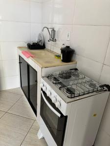 a kitchen with a stove and a sink at Kitnet Encanto Astral in São Thomé das Letras +10 photos