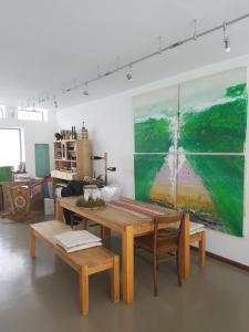 ein Esszimmer mit einem Tisch und einem Gemälde an der Wand in der Unterkunft Weinek's Kellerstöckl u. Lodge in Güssing