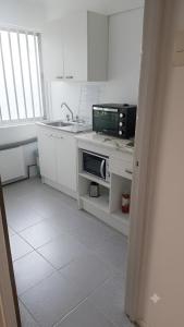 a kitchen with a sink and a microwave at Dpto céntrico en primer piso in Valdivia