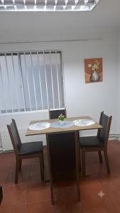 a table with two chairs and a table with a bowl on it at Dpto céntrico en primer piso in Valdivia +3 photos