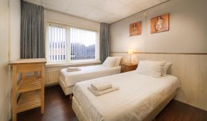 アウウドルプにあるHotel-Pension Ouddorpのベッド2台と窓が備わるホテルルームです。